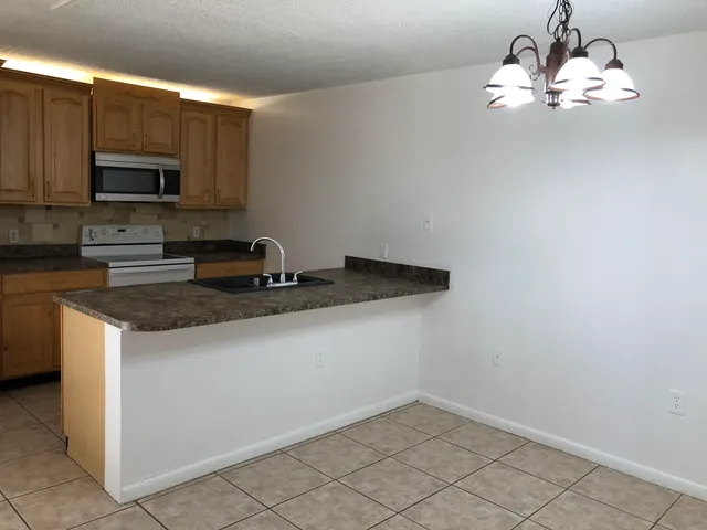 a kitchen with stainless steel appliances a sink a stove a microwave and cabinets