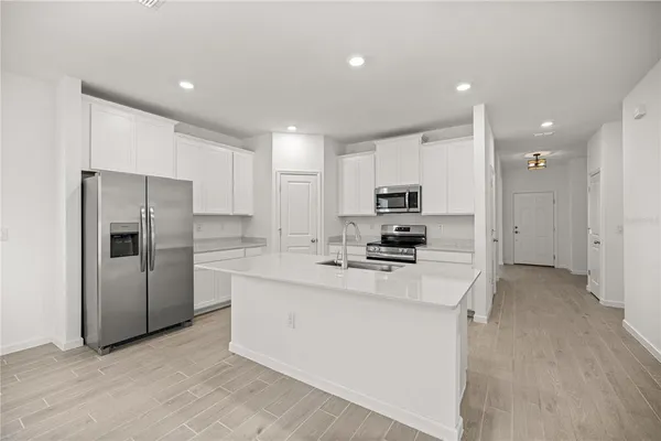 a kitchen with stainless steel appliances a sink stove refrigerator and cabinets