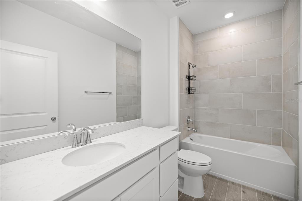 1604 Northwest 44th Court Road Ocala, FL 34482 - Photo 28 of 41 a bathroom with a granite countertop toilet sink and a bathtub