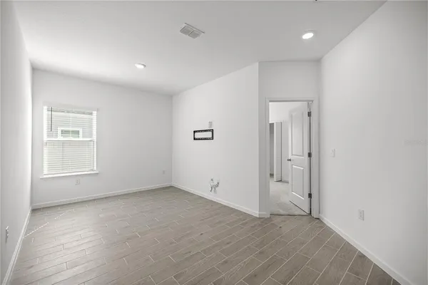 a view of a big room with wooden floor and windows