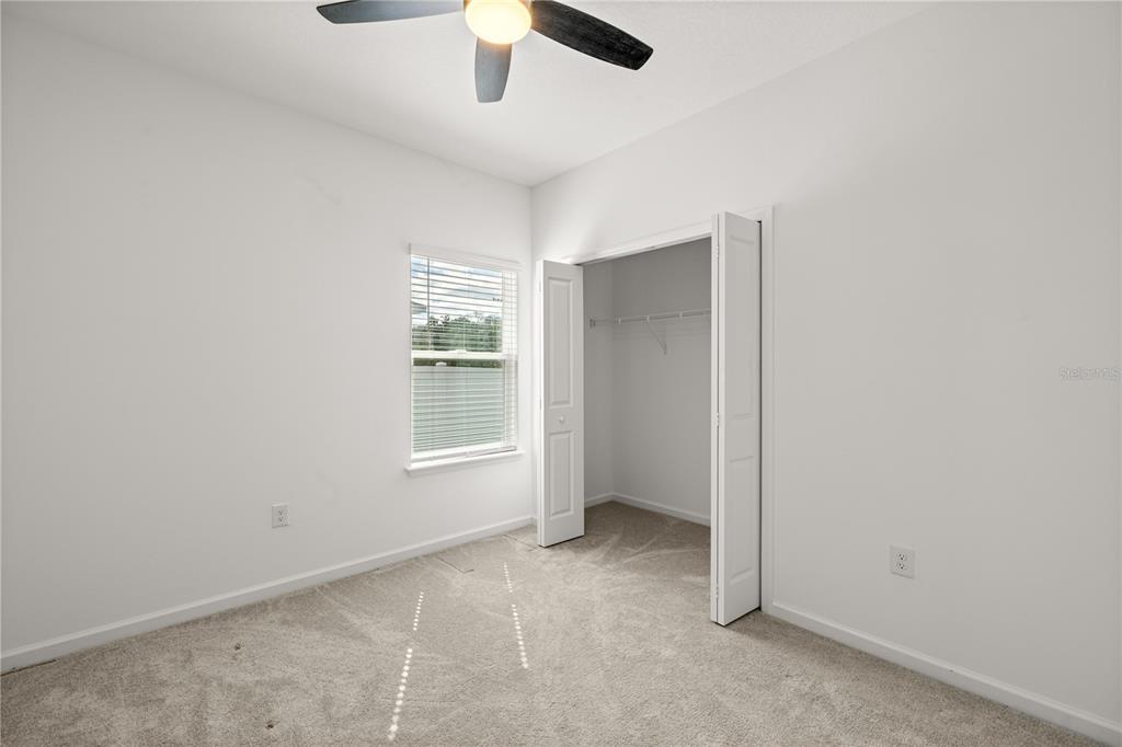 1604 Northwest 44th Court Road Ocala, FL 34482 - Photo 32 of 41 an empty room with chandelier fan and windows