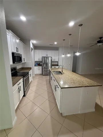 a kitchen with granite countertop a sink and a stove top oven