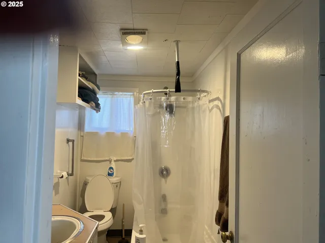 a bathroom with a granite countertop sink mirror vanity and toilet