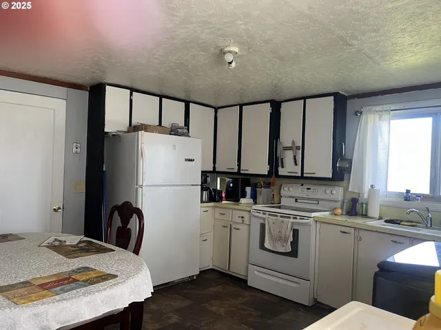 a kitchen with a sink a refrigerator and window