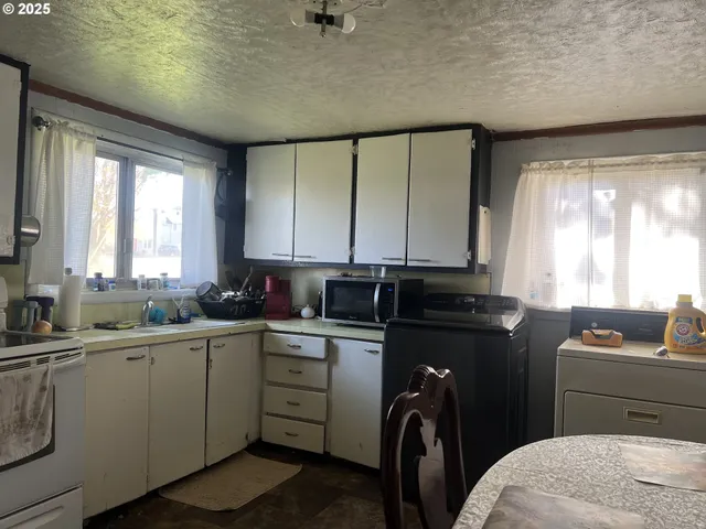 a kitchen with stainless steel appliances granite countertop a sink a stove a refrigerator a counter space and cabinets