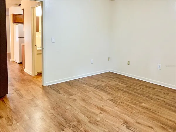 a view of empty room with wooden floor and windows