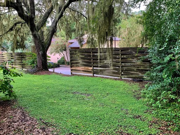 a view of a house with backyard and wooden fence