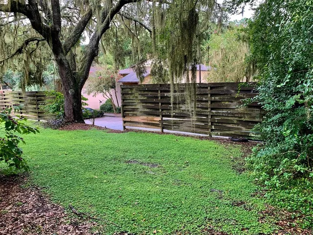 a view of a house with backyard and wooden fence