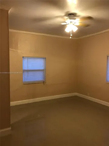 a view of an empty room with a chandelier fan