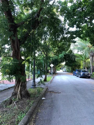 a view of a street with trees and plants