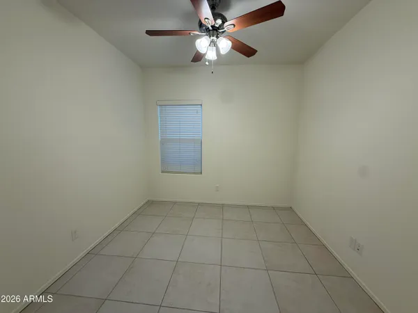 an empty room with a ceiling fan and a window