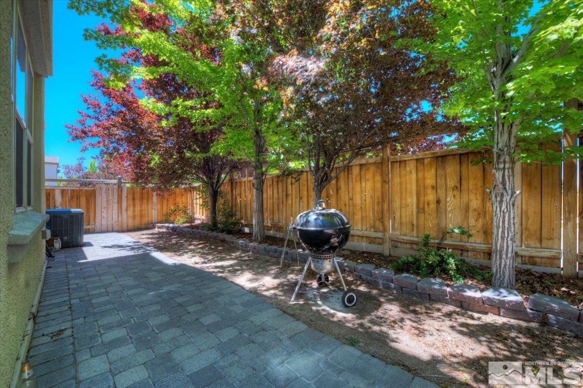 6923 Sacred Circle Sparks, NV 89436 - Photo 12 of 27 a view of a backyard with table and chairs and a large tree