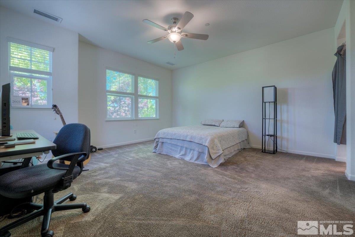 6923 Sacred Circle Sparks, NV 89436 - Photo 16 of 27 a spacious bedroom with a bed and a chandelier