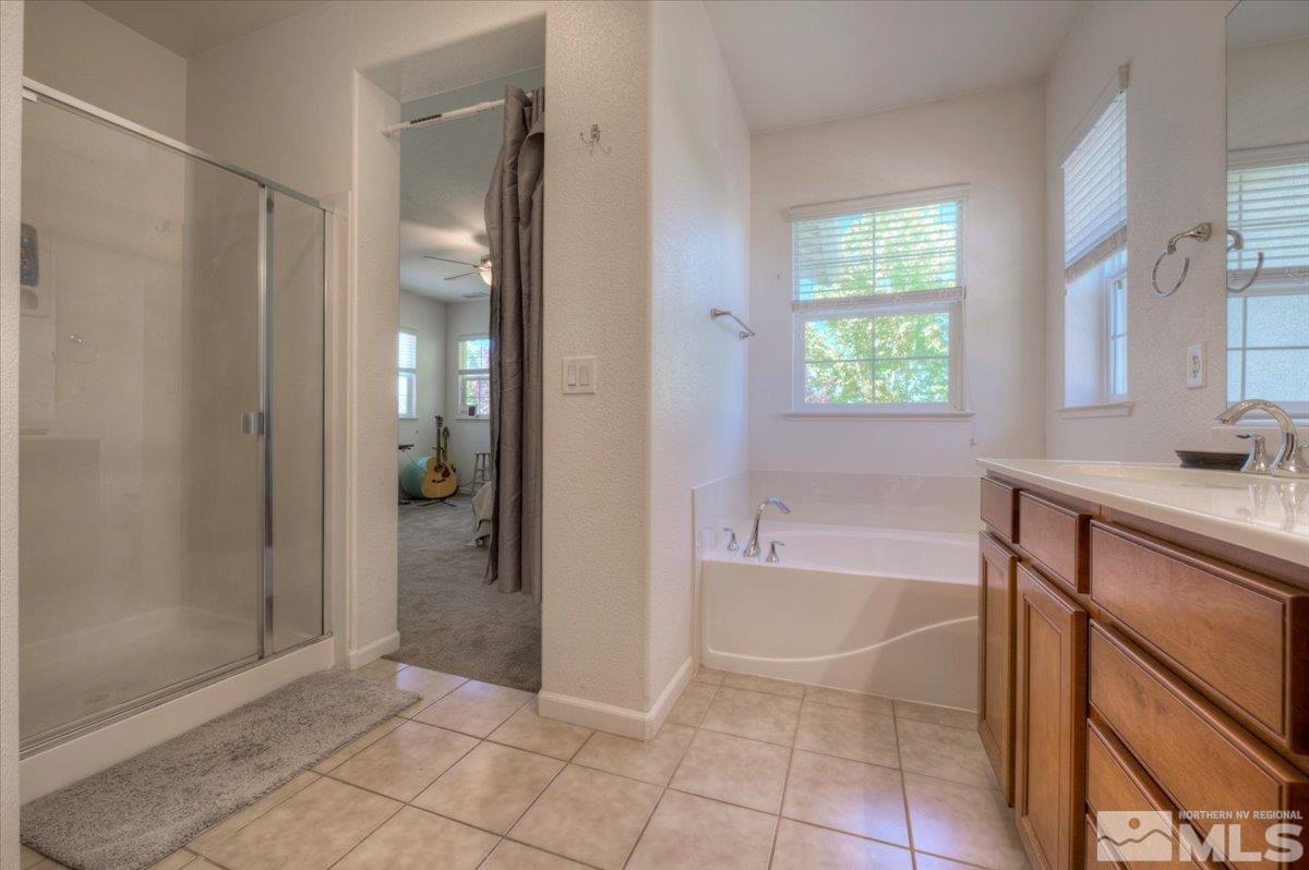 6923 Sacred Circle Sparks, NV 89436 - Photo 18 of 27 a bathroom with a bathtub and a shower