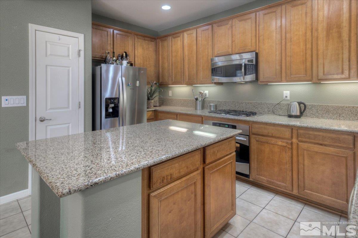 6923 Sacred Circle Sparks, NV 89436 - Photo 5 of 27 a kitchen with stainless steel appliances granite countertop a sink stove and refrigerator