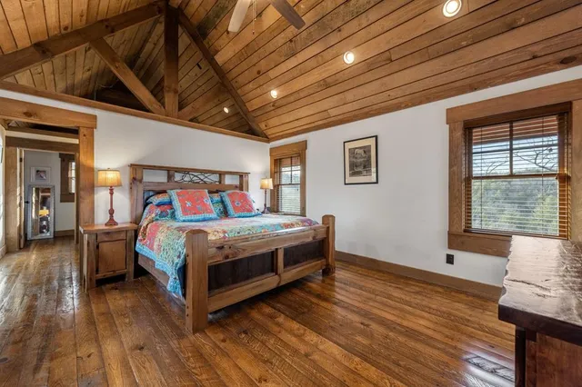 a bedroom with a bed wooden floor and window