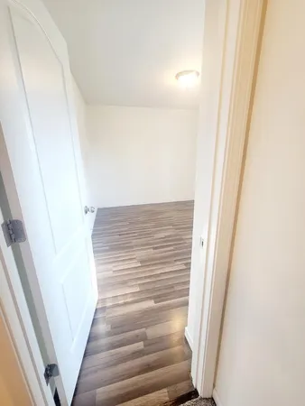 a view of staircase with white walls and white door
