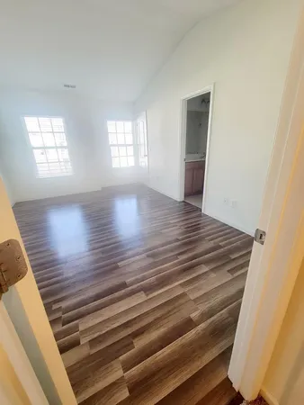 a view of wooden floor and windows in a room