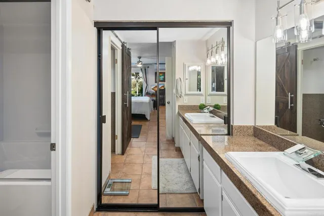 a en suite bathroom with a granite countertop sink and a mirror