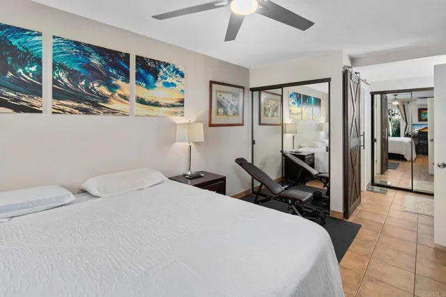 a bedroom with a bed a wall painting and a large mirror