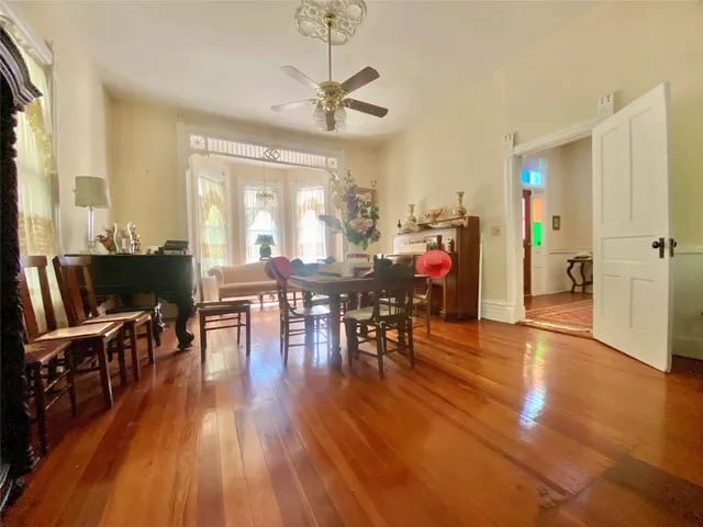 a view of a house next to a big yard and large trees