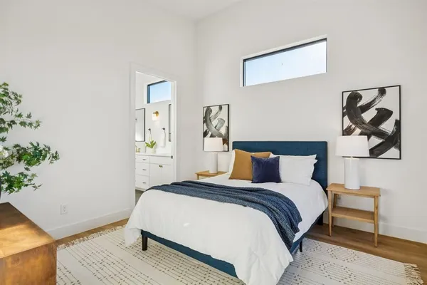 a bedroom with a bed and painting on the wall