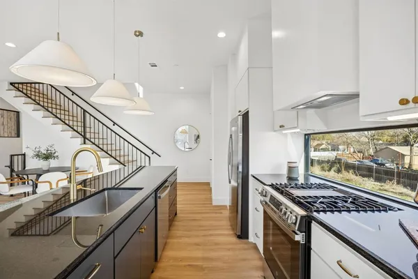 a kitchen with granite countertop a stove and a sink