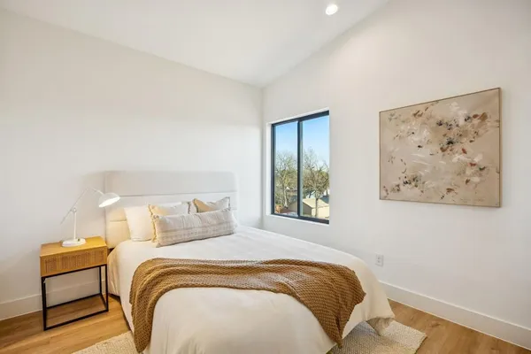 a bedroom with a bed and a painting on the wall