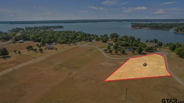 an aerial view of a house with a yard and ocean view