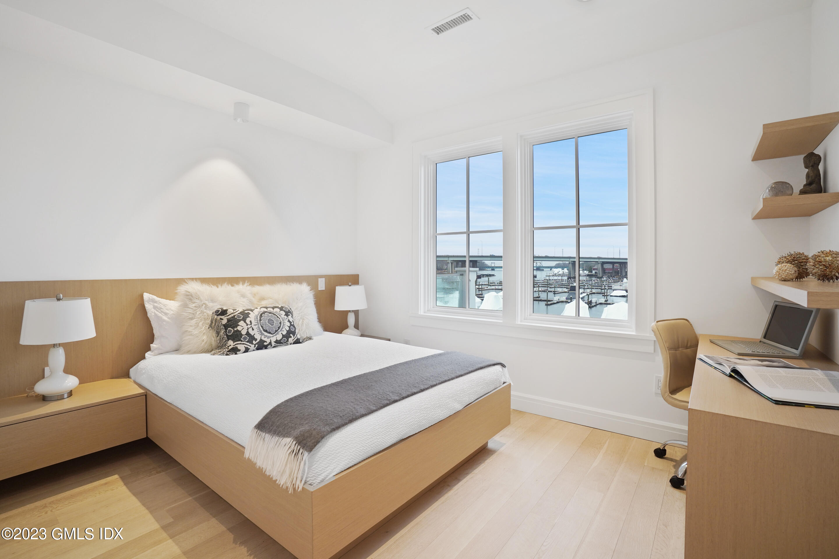 89 River Road, Unit 205 Cos Cob, CT 06807 - Photo 8 of 19 a bedroom with a bed wooden floor and a large window
