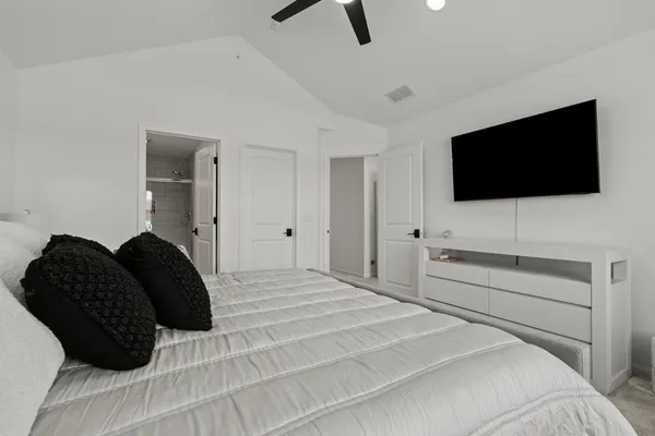 a bedroom with a bed a television and a window