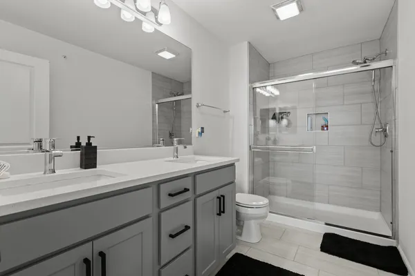a bathroom with a double vanity sink toilet and shower