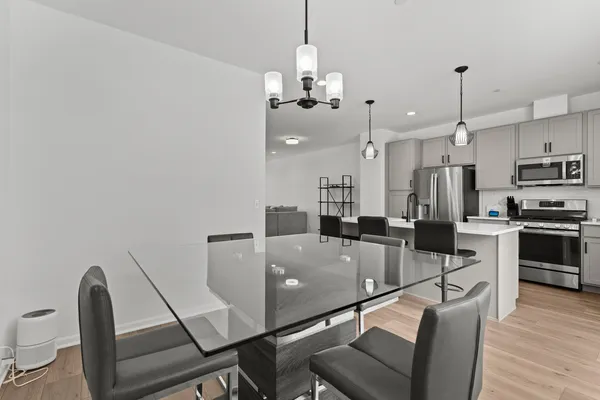 a very nice looking dining room with furniture wooden floor and chandelier