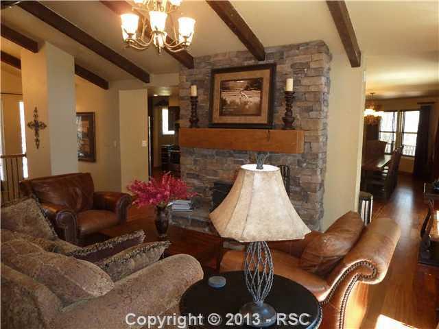9080 Hardin Road Colorado Springs, CO 80908 - Photo 4 of 25 Family room with stone fireplace. Furniture included!