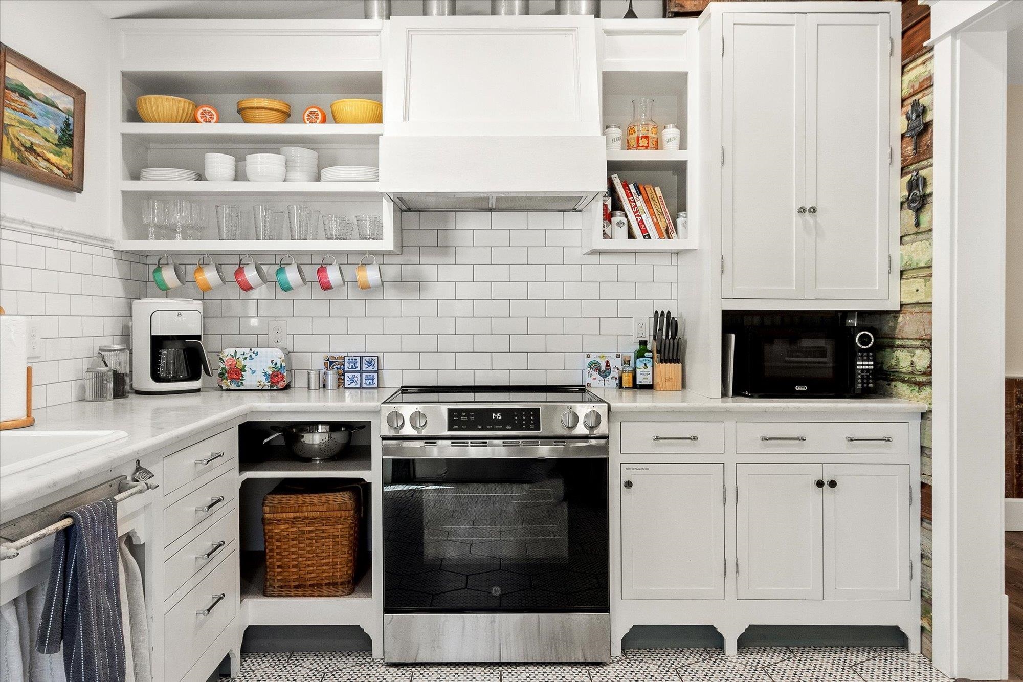 16 Locust Street St. Augustine, FL 32084 - Photo 12 of 75 a kitchen with stainless steel appliances granite countertop white cabinets and a stove a oven with wooden floor