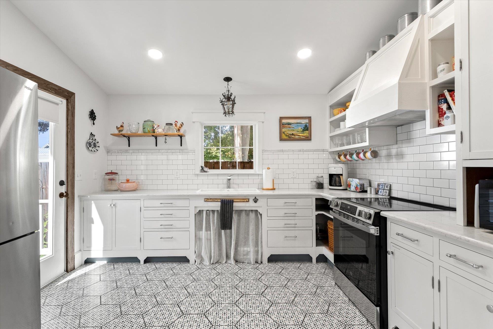 16 Locust Street St. Augustine, FL 32084 - Photo 37 of 76 Kitchen featuring open shelves, electric range, white cabinets, freestanding refrigerator, and custom range hood