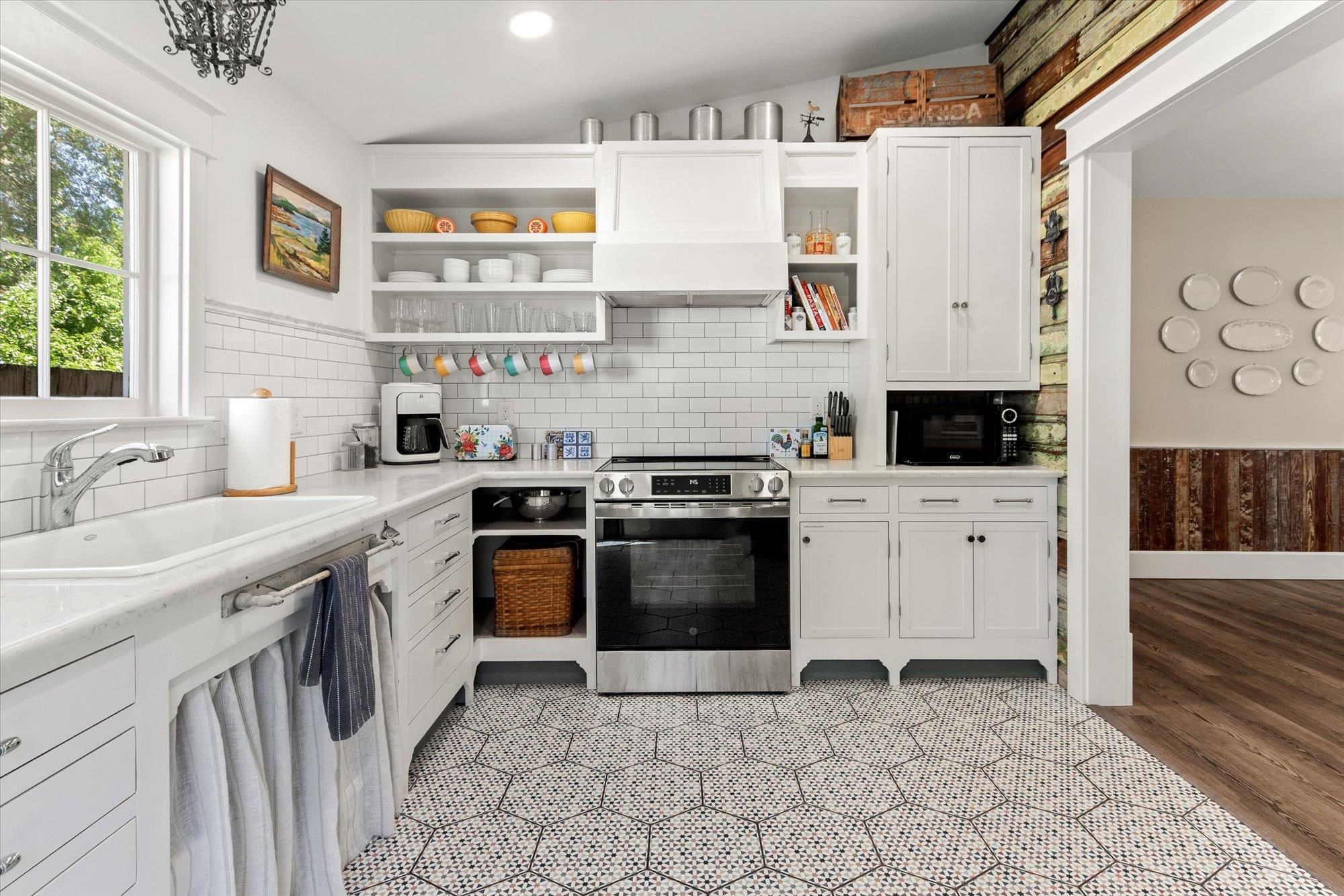 16 Locust Street St. Augustine, FL 32084 - Photo 38 of 76 Kitchen featuring stainless steel range with electric stovetop, open shelves, white cabinets, vaulted ceiling, and decorative backsplash