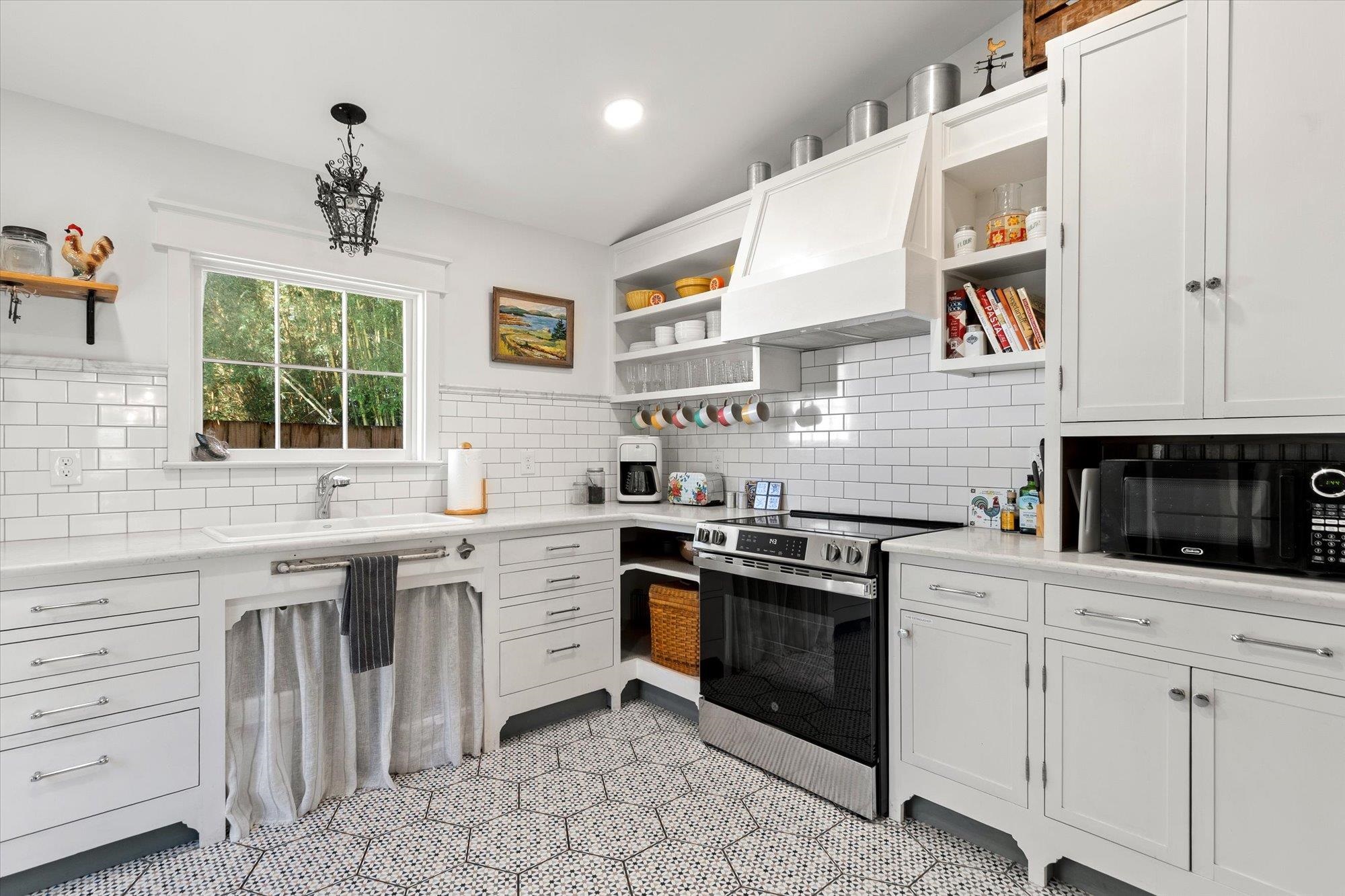 16 Locust Street St. Augustine, FL 32084 - Photo 40 of 76 Kitchen with open shelves, stainless steel electric range, premium range hood, black microwave, and recessed lighting