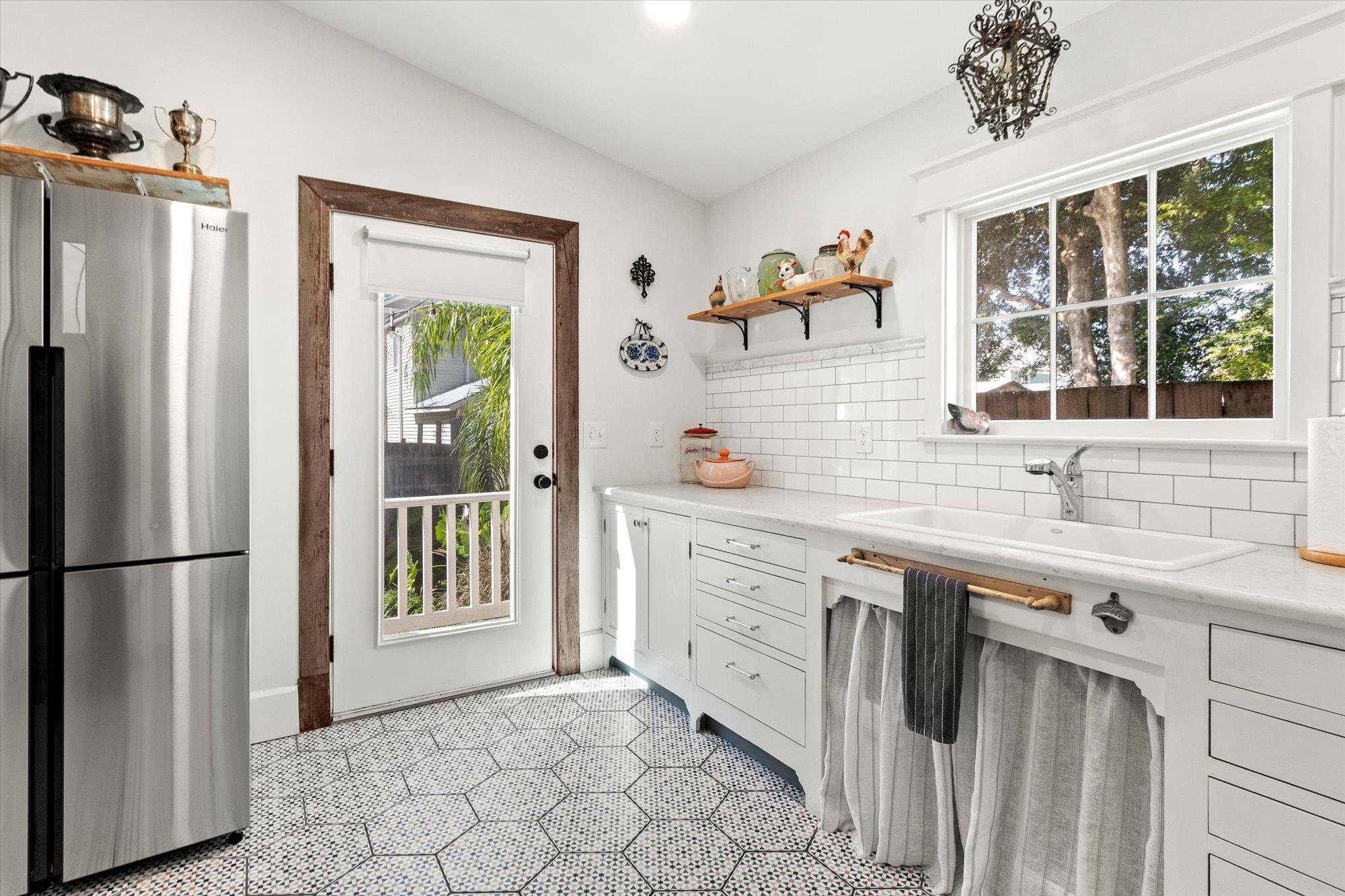 16 Locust Street St. Augustine, FL 32084 - Photo 41 of 76 Kitchen with freestanding refrigerator, open shelves, white cabinetry, decorative backsplash, and lofted ceiling