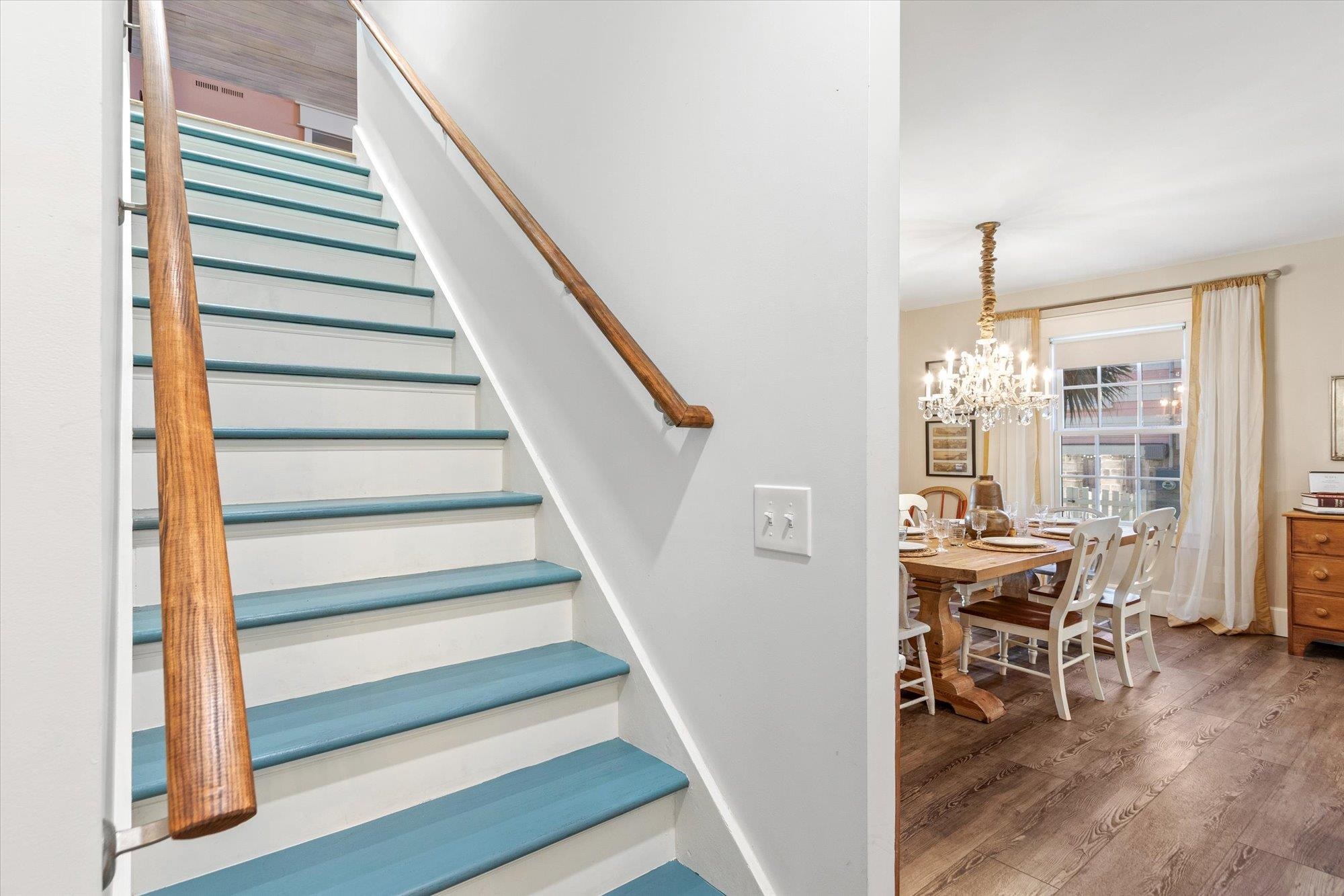 16 Locust Street St. Augustine, FL 32084 - Photo 9 of 75 Stairway with wood finished floors and a chandelier