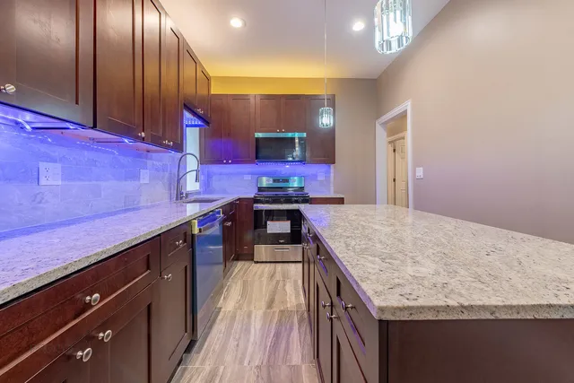 a kitchen with a stove and a wooden floor