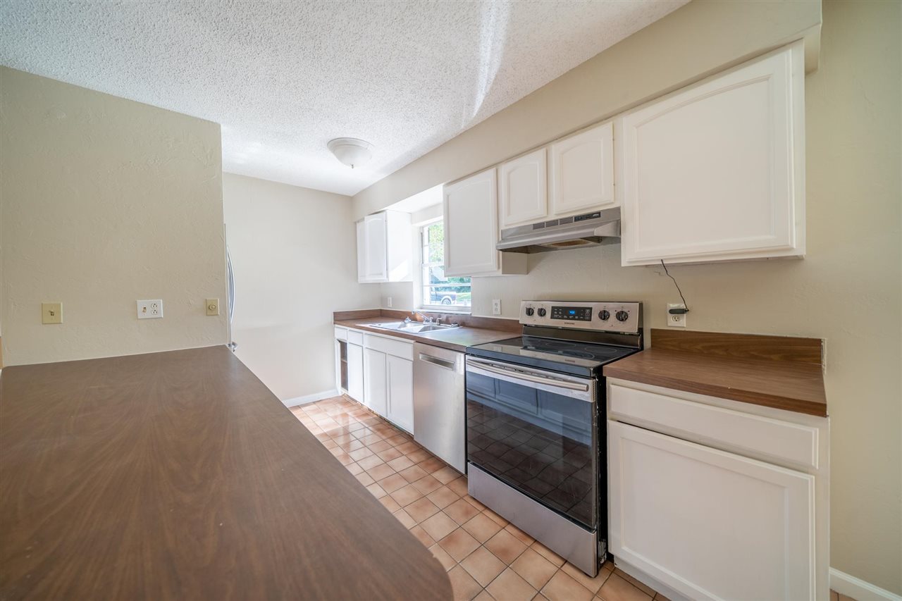 626 Segovia Road St. Augustine, FL 32086 - Photo 11 of 30 a kitchen with granite countertop white cabinets and white appliances