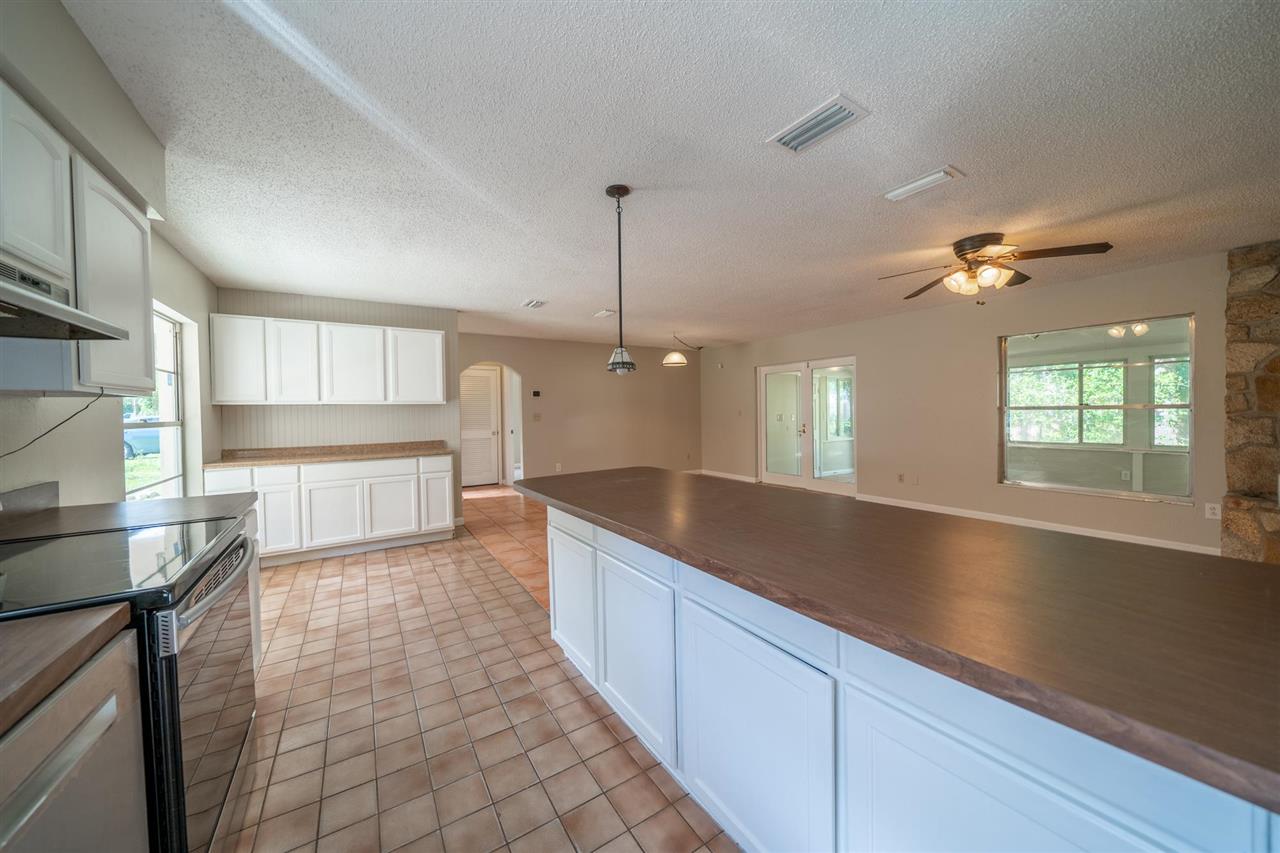 626 Segovia Road St. Augustine, FL 32086 - Photo 9 of 30 a large kitchen with kitchen island a large counter space a sink appliances and cabinets