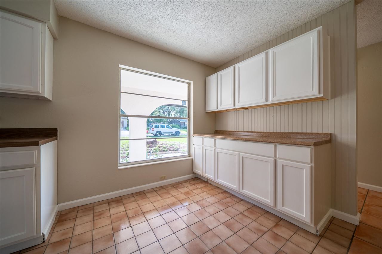 626 Segovia Road St. Augustine, FL 32086 - Photo 10 of 30 a kitchen with white cabinets and window