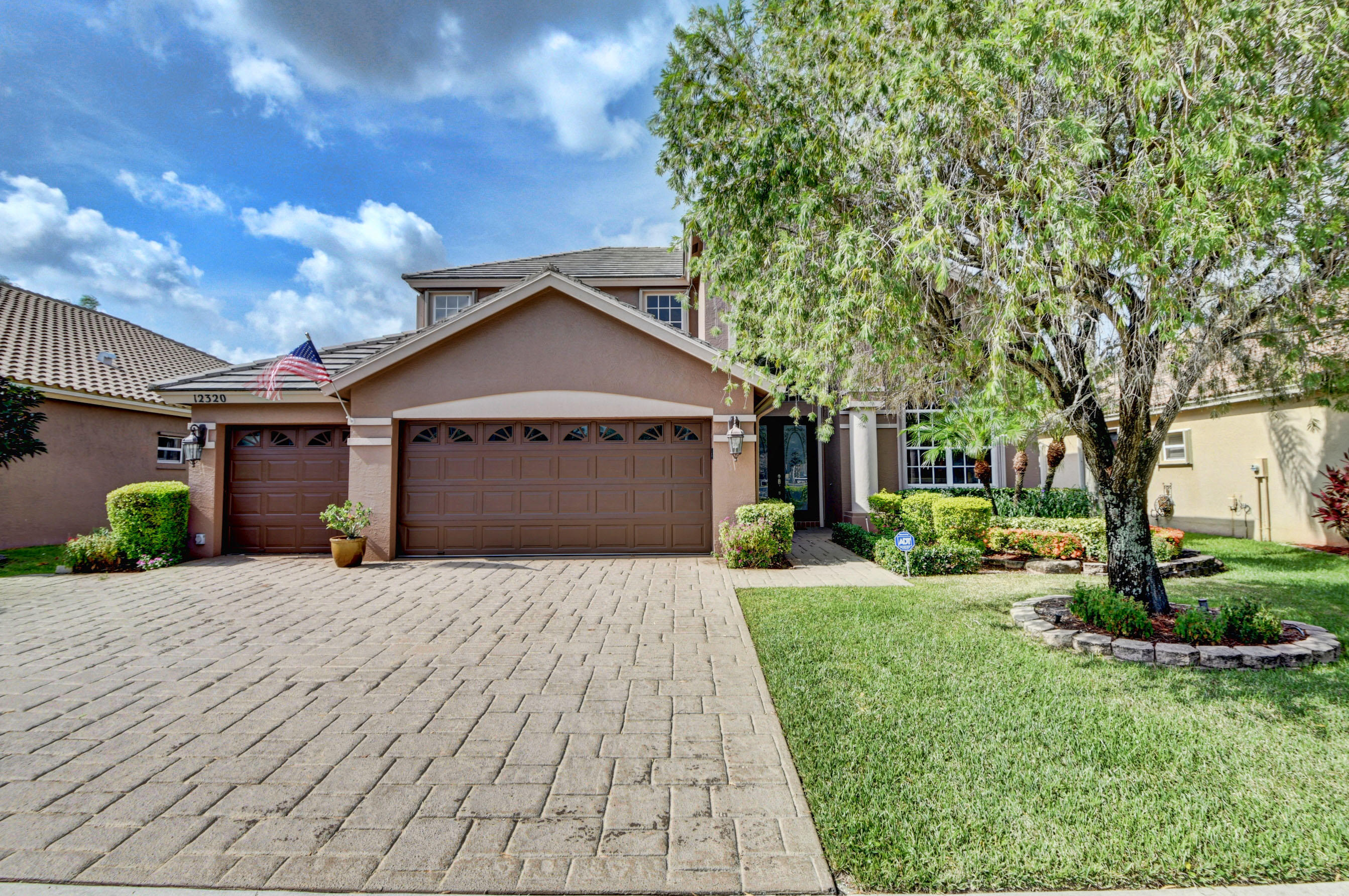 12320 Melrose Way Boca Raton, FL 33428 - Photo 1 of 34 a front view of a house with a yard and garage