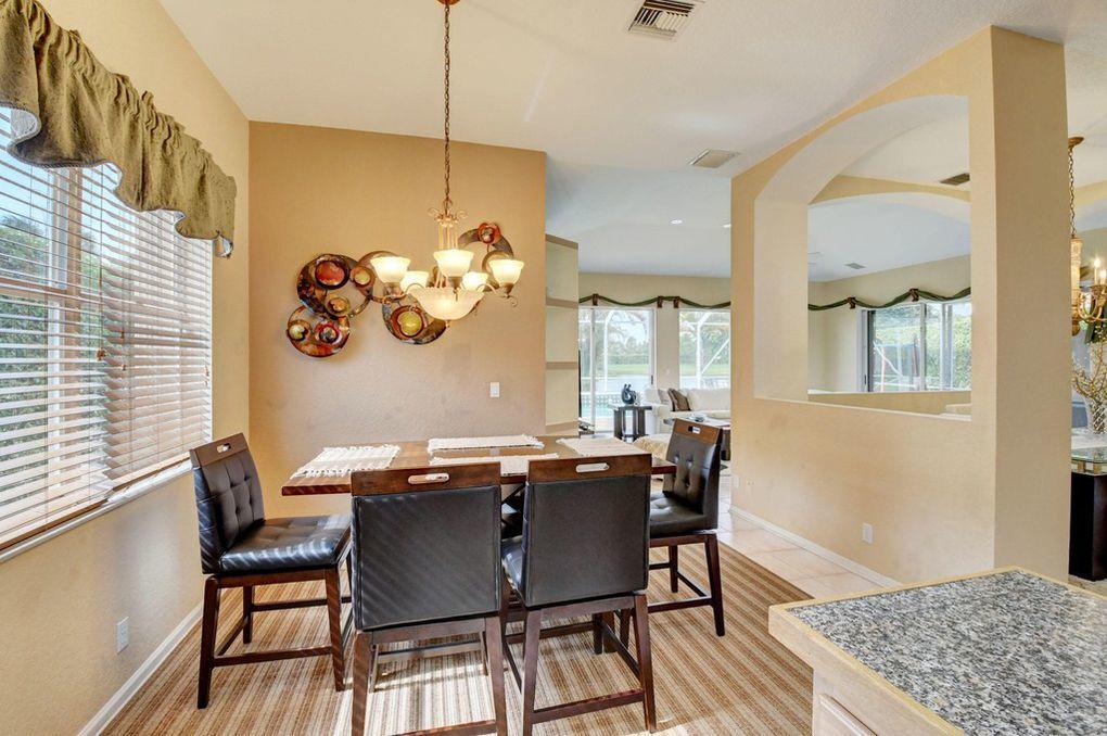 12320 Melrose Way Boca Raton, FL 33428 - Photo 15 of 34 a view of a dining room with furniture a chandelier and wooden floor