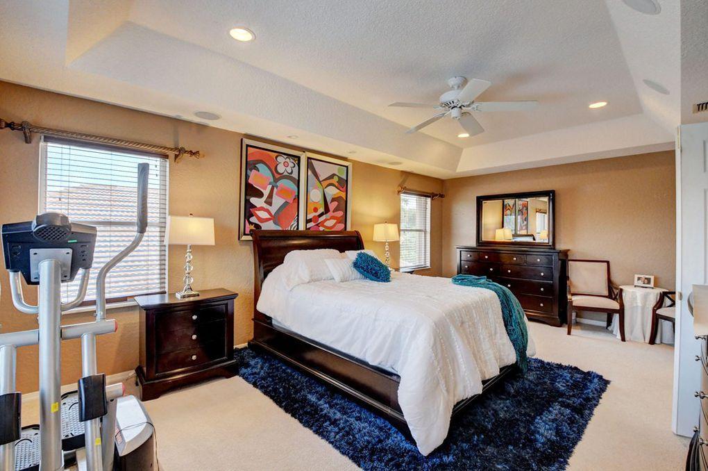 12320 Melrose Way Boca Raton, FL 33428 - Photo 19 of 34 a bedroom with a bed a dresser and paintings on the wall