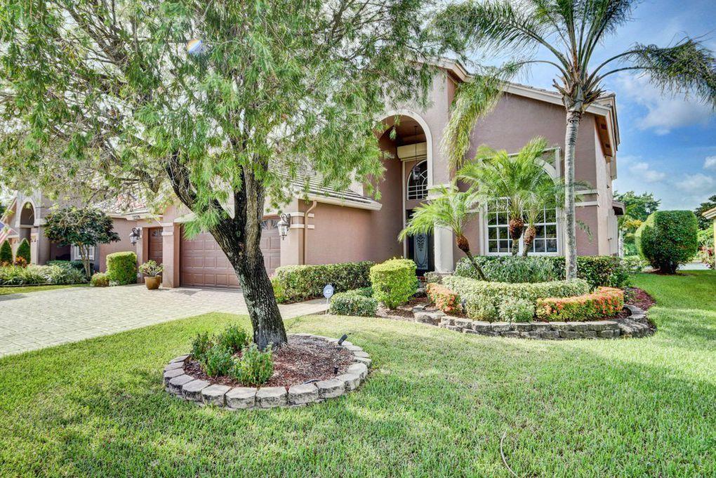 12320 Melrose Way Boca Raton, FL 33428 - Photo 2 of 34 a front view of a house with a yard and garage