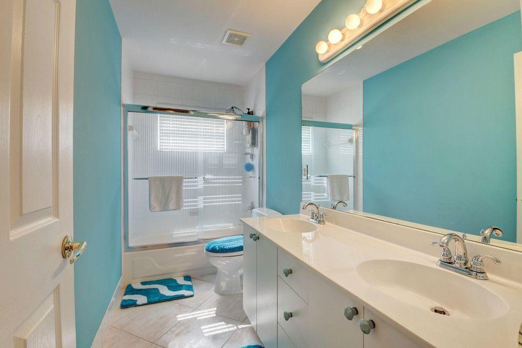 12320 Melrose Way Boca Raton, FL 33428 - Photo 24 of 34 a bathroom with a granite countertop sink a toilet and shower