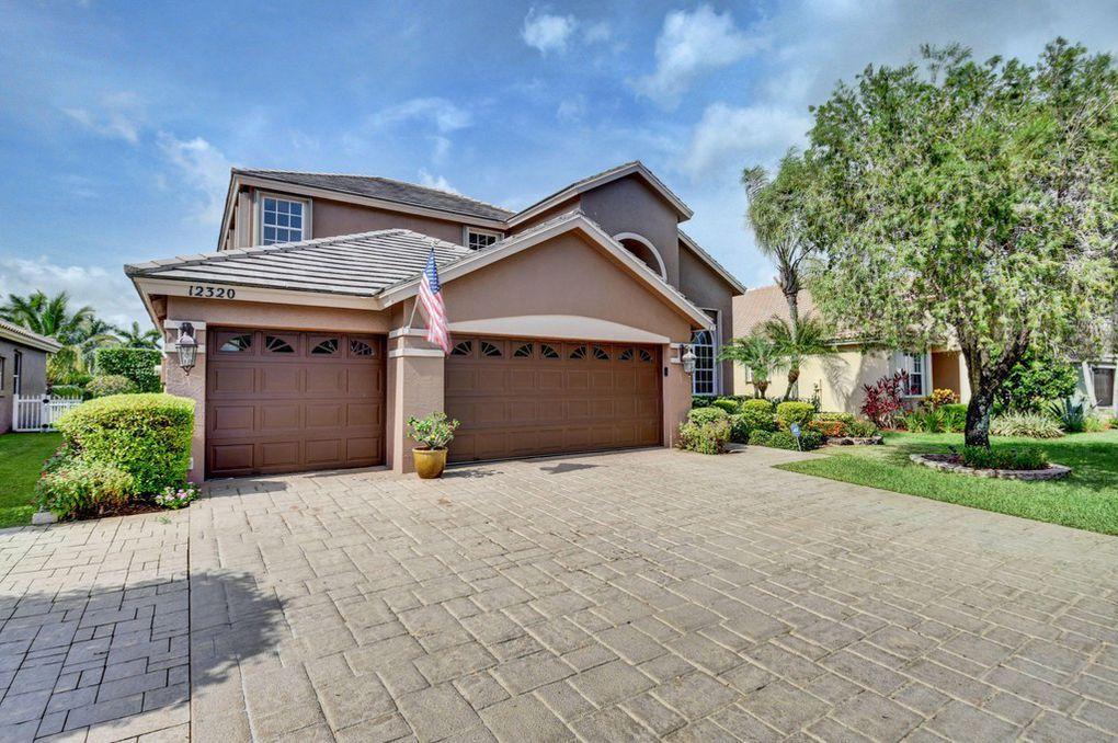 12320 Melrose Way Boca Raton, FL 33428 - Photo 3 of 34 a front view of a house with a yard and garage